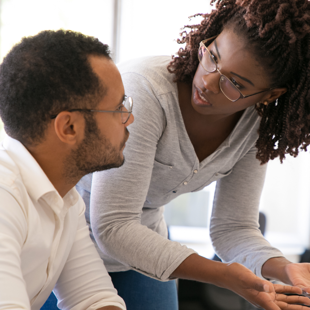 Photo of a woman explaining to a man the instructions for logging into the administrator account on the ITS platform, creating a test, and identifying the skills to evaluate