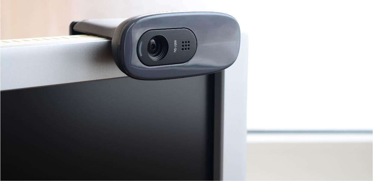 Photo of a camera mounted on a computer screen, illustrating our surveillance solutions to prevent cheating during online assessments